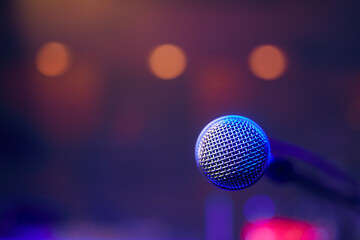 Close-up of lluminated microphone on stage against spotlights..