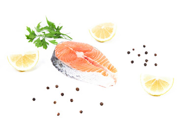 Salmon, slice of fresh raw fish with lemon slices, parsley and black pepper, isolated on white background