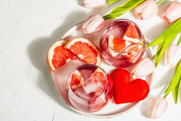 Non-alcoholic cocktail with grapefruit. An iced drink is served in glasses. St.Valentine's symbol