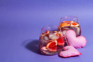 Non-alcoholic cocktail with grapefruit. An iced drink is served in glasses. St.Valentine's symbol
