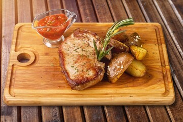 Grilled tasty meat dish on wooden board