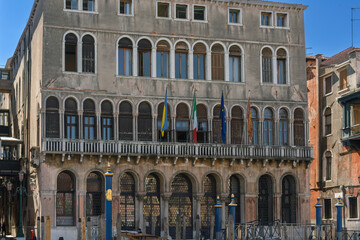 Fototapeta na wymiar Flag of Ukraine, the European Union, the flag of Italy and Venice on the vintage wall of an administrative building in the street of the city of Venice. European solidarity with the struggle Ukraine