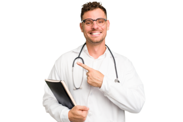 Young doctor caucasian man holding a book isolated smiling and pointing aside, showing something at blank space.