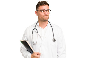 Young doctor caucasian man holding a book isolated confused, feels doubtful and unsure.