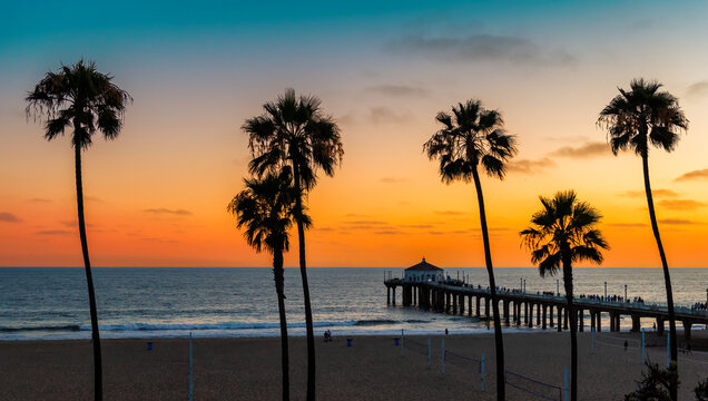 Sunset beach with palm trees in Manhattan Beach, California. Fashion travel and tropical beach concept.