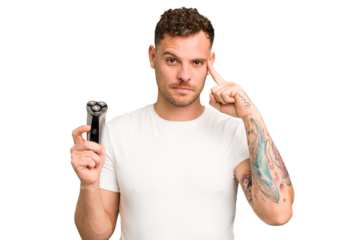 Young caucasian man holding a razor isolated pointing temple with finger, thinking, focused on a task.