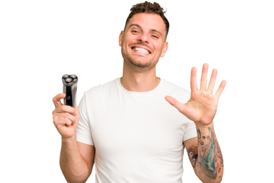 Young caucasian man holding a razor isolated smiling cheerful showing number five with fingers.