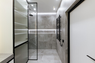 bathroom interior design with gray tiles and glass shower wall