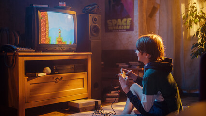 Young Boy Playing Eighties Eight Bit Arcade Video Game on a Console at Home in His Room with Old-School Interior. Child Successfully Wins the Complicated Level. Nostalgic Retro Childhood Concept.