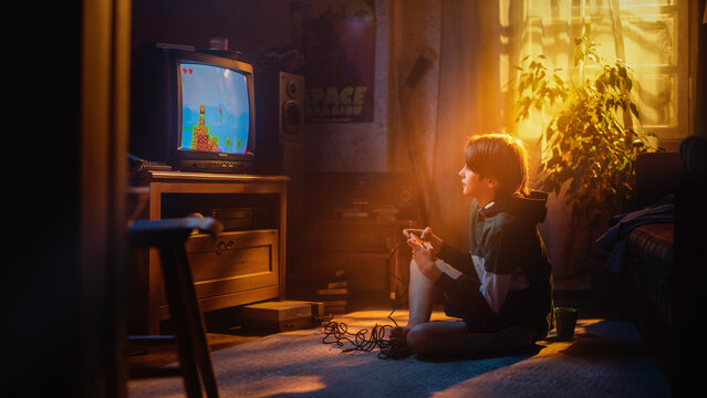 Handsome Child Playing Eight Bit Arcade Video Game on a Console at Home in His Room with Eighties Interior. Young Boy Reaches End of Level and Wins. Nostalgic Retro Childhood Concept.