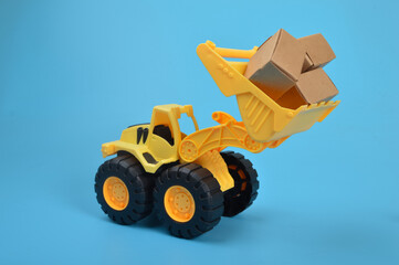 Yellow backhoe with paper boxes isolated on a blue background.