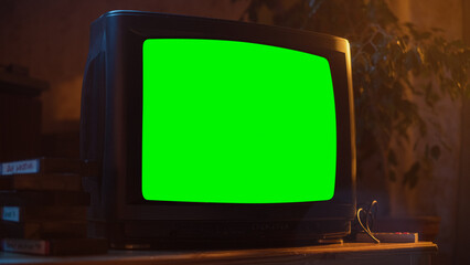 Close Up Footage of a Dated TV Set with Green Screen Mock Up Chroma Key Template Display. Nostalgic Retro Nineties Technology Concept. Vintage Television Display in Living Room.