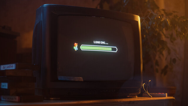 Close Up Footage of a Retro TV Set Screen with an Eight Bit Eighties Inspired Console Arcade Video Game. Quest Loading, Player Waiting to Start a New Harder Level. Green Progress Bar Moving.