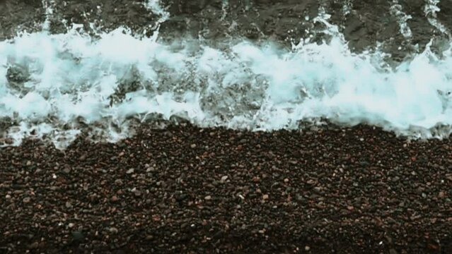 Sea surf. It is shown in detail how the sea wave changes when rolling on a pebble beach. Super slow motion 1000 fps.