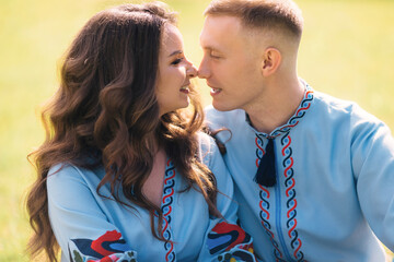 cute newlyweds in blue shirts are smiling looking at each other