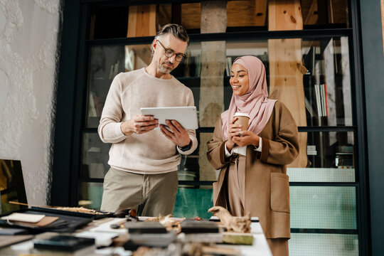 Two multiracial colleagues working together in workshop - Powered by Adobe