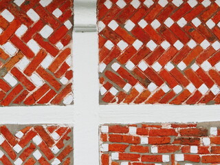 Fototapeta na wymiar Wall detail with red bricks and white beams at a Dutch countryside house