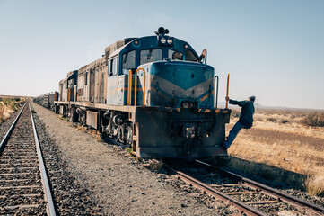 Zugführer klettert auf seine Lok - Güterzug im Süden von Namibia - obrazy, fototapety, plakaty