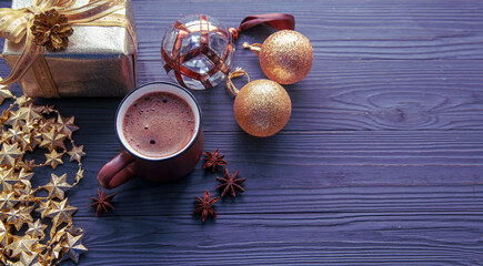 Christmas mood, holiday atmosphere. A cup of coffee, golden Christmas decorations and gifts on a dark wooden table background.