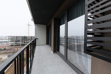 a new clean balcony with large windows in an apartment building