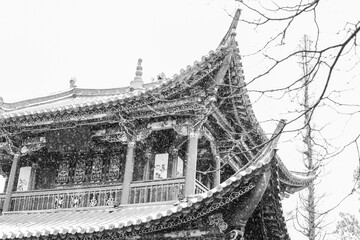 TRaditional Chinese pavilion roof in winter covered in snow monochrome