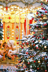 Christmas holiday background. Beautiful decorated Christmas tree and horse carousel on traditional Christmas market. Christmas and New Year concept. festive winter season.