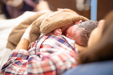出産後に分娩室でカンガルーケアをする親子