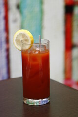 Red cocktail with lemon slice and glass stirrer