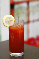 Red cocktail with lemon slice and glass stirrer