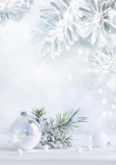 Winter background with snowy fir branches, pine cones and transparent Christmas ball. Winter or Christmas festive scene.