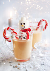 Traditional Christmas Eggnog with sweet treat snowman marshmallow and candy cane peppermint