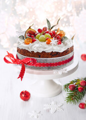 Traditional Christmas fruit cake with white frosting and sugared fruits.