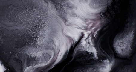 Fototapeta premium Abstract black white fluid background. Black silver ink spreads, close-up. Black-white liquid paints texture. Vertical. Shiny sequins spread in grunge paint. Dark gray paint
