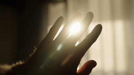 male hand playing with sunlight glare coming through window - Powered by Adobe