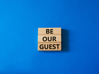 Be our guest symbol. Concept word Be our guest on wooden blocks. Beautiful blue background. Business and Be our guest concept. Copy space