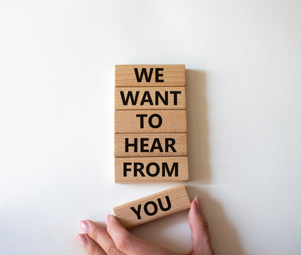 We want to hear from you symbol. Wooden blocks with words We want to hear from you. Beautiful white background. Businessman hand. Business and We want to hear from you. Copy space.