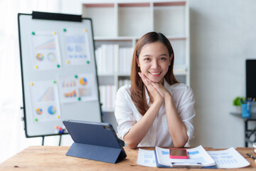 Obraz na płótnie Canvas Happy beautiful Asian businesswoman smiling and enjoying working in office and looking at camera.