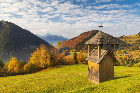 A small wooden bell tower in the foreground of a mountain landscape. Mala Fatra National Park, near the village of Zazriva in Slovakia, Europe
