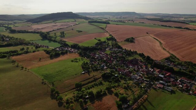 Aer ial view of a German village surrounded by meadows, farmland and forest in Germany.
