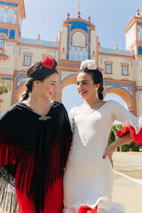 Happy Hispanic women in national outfit standing on street