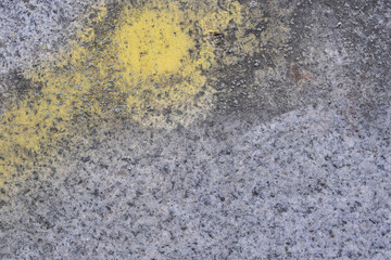Old yellow paint on gray granite stone surface - abstract background