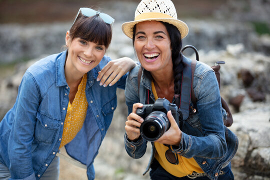 two women taking photos outdoors