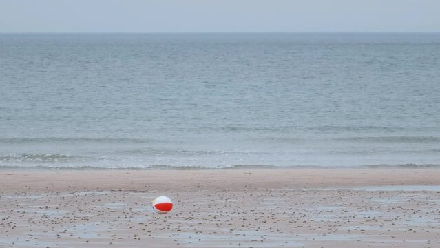 Children's Multi-coloured Ball Rolling In The Wind On A Sea Beach. Scotland