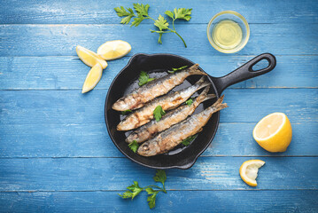 Fried sardines on the small  а frying pan
 in a marine style served with parsley, lemon and olive...