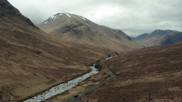 Aerial view of a car driving in the Glen Etive in Scottish highlands, UK