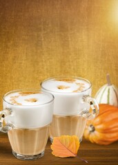 Tasty coffee with foam  and pumpkin on the desk