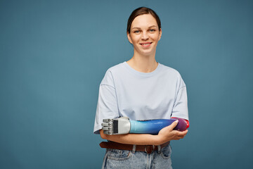 Studio portrait of positive young woman with bionic arm