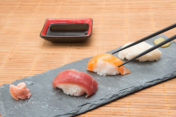 Tuna and salmon sushi on stone with soy sauce