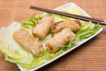 Plate of Vietnamese rolls with chopsticks on endive