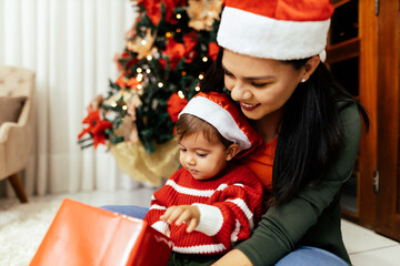 Mother and her baby playing at home on Christmas holiday